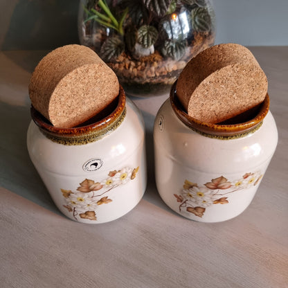Pair of Kermiko Potteries floral ceramic jars with cork lids.