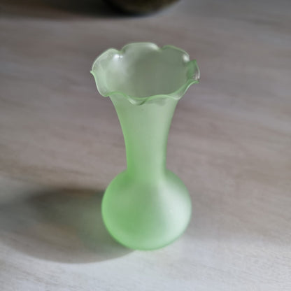 Vintage frosted green glass bud vase with ruffled rim and matte finish.
