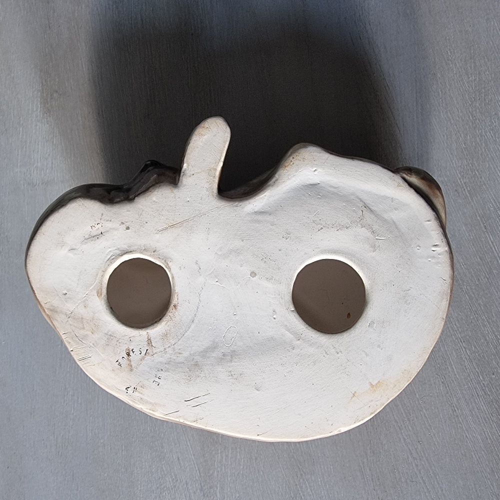 Vintage ceramic sleeping dog figurine in brown and cream glaze.