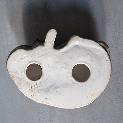 Vintage ceramic sleeping dog figurine in brown and cream glaze.