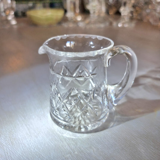 Pressed glass mini jug with scalloped rim and diamond-cut pattern.