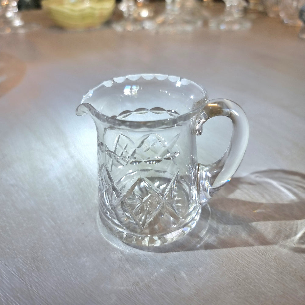 Pressed glass mini jug with scalloped rim and diamond-cut pattern.