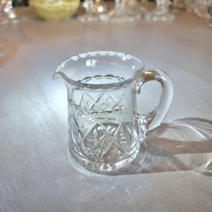 Pressed glass mini jug with scalloped rim and diamond-cut pattern.