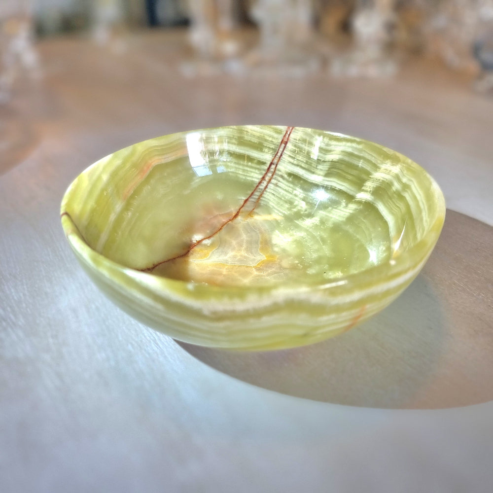 Green onyx dish with natural veining and soft layered tones.