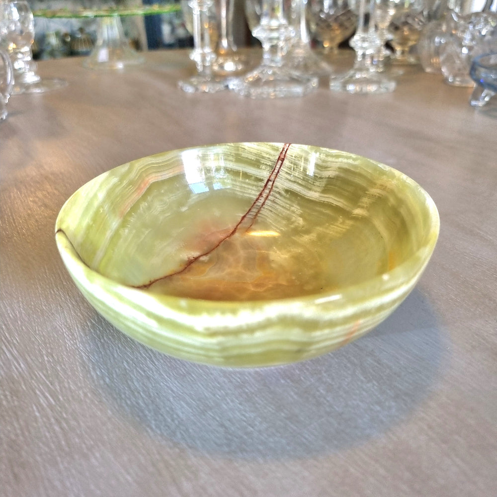 Green onyx dish with natural veining and soft layered tones.