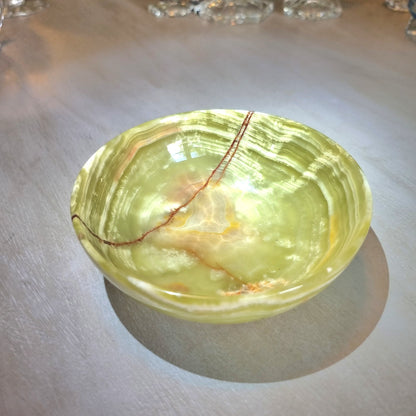 Green onyx dish with natural veining and soft layered tones.