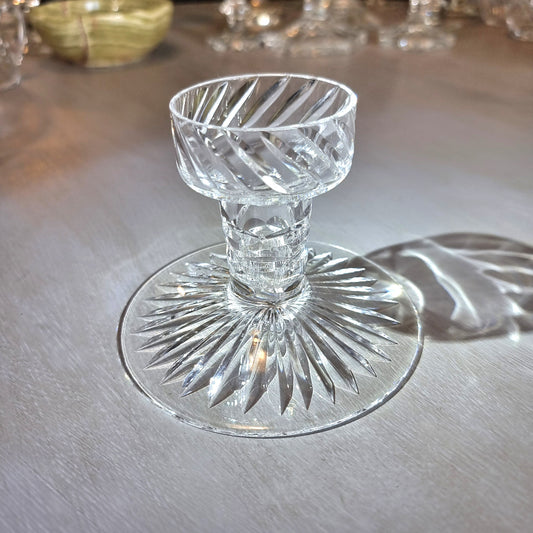 Crystal candle holder with cut starburst base and faceted swirl-pattern cup.