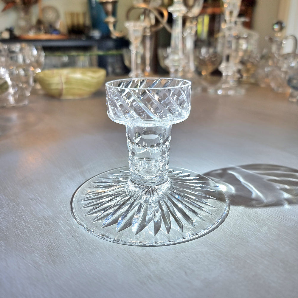 Crystal candle holder with cut starburst base and faceted swirl-pattern cup.