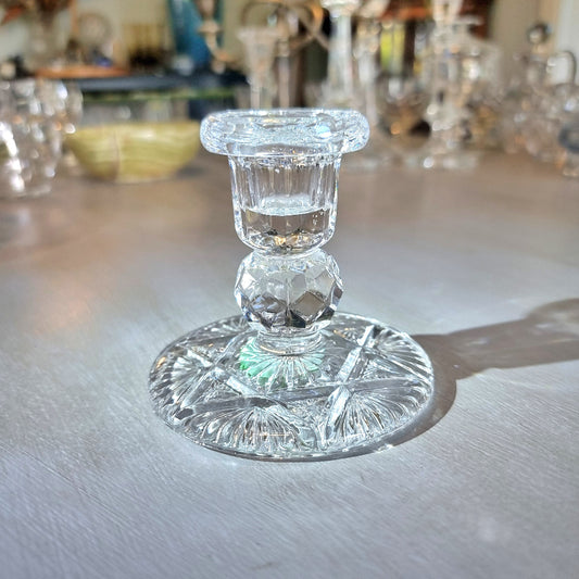 Crystal taper candle holder with faceted stem and starburst-pattern base.