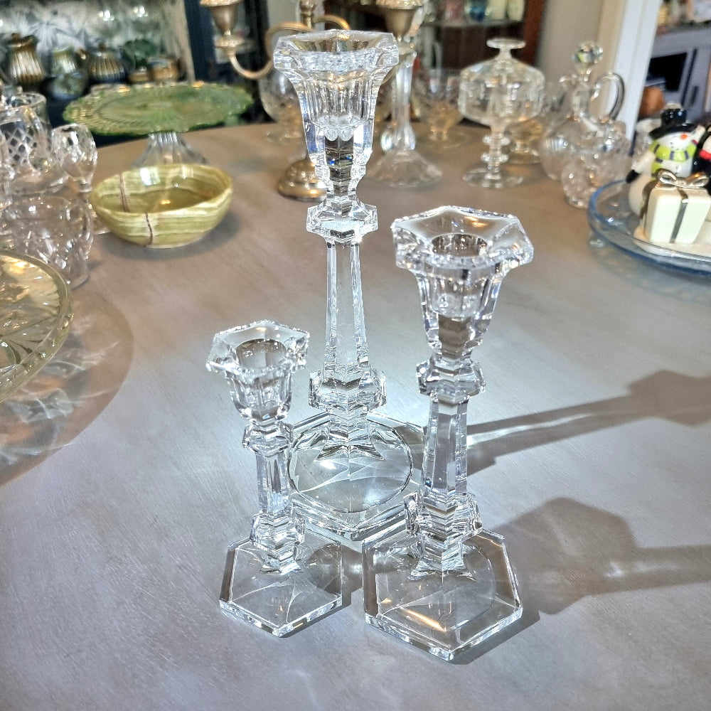 Set of three crystal candle holders with faceted stems and hexagonal bases in varying heights.