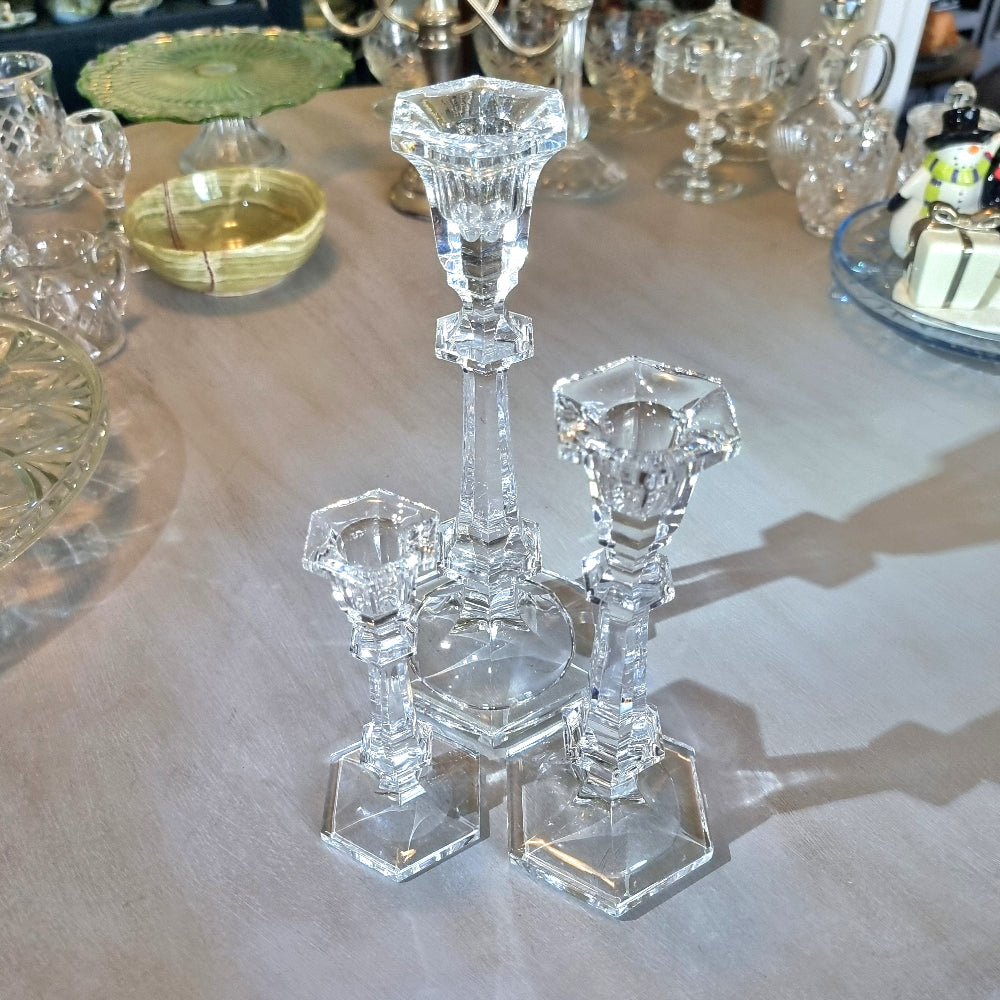 Set of three crystal candle holders with faceted stems and hexagonal bases in varying heights.