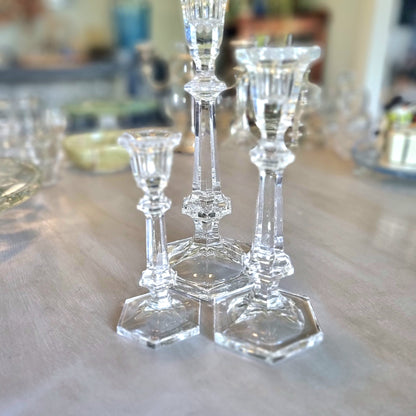 Set of three crystal candle holders with faceted stems and hexagonal bases in varying heights.