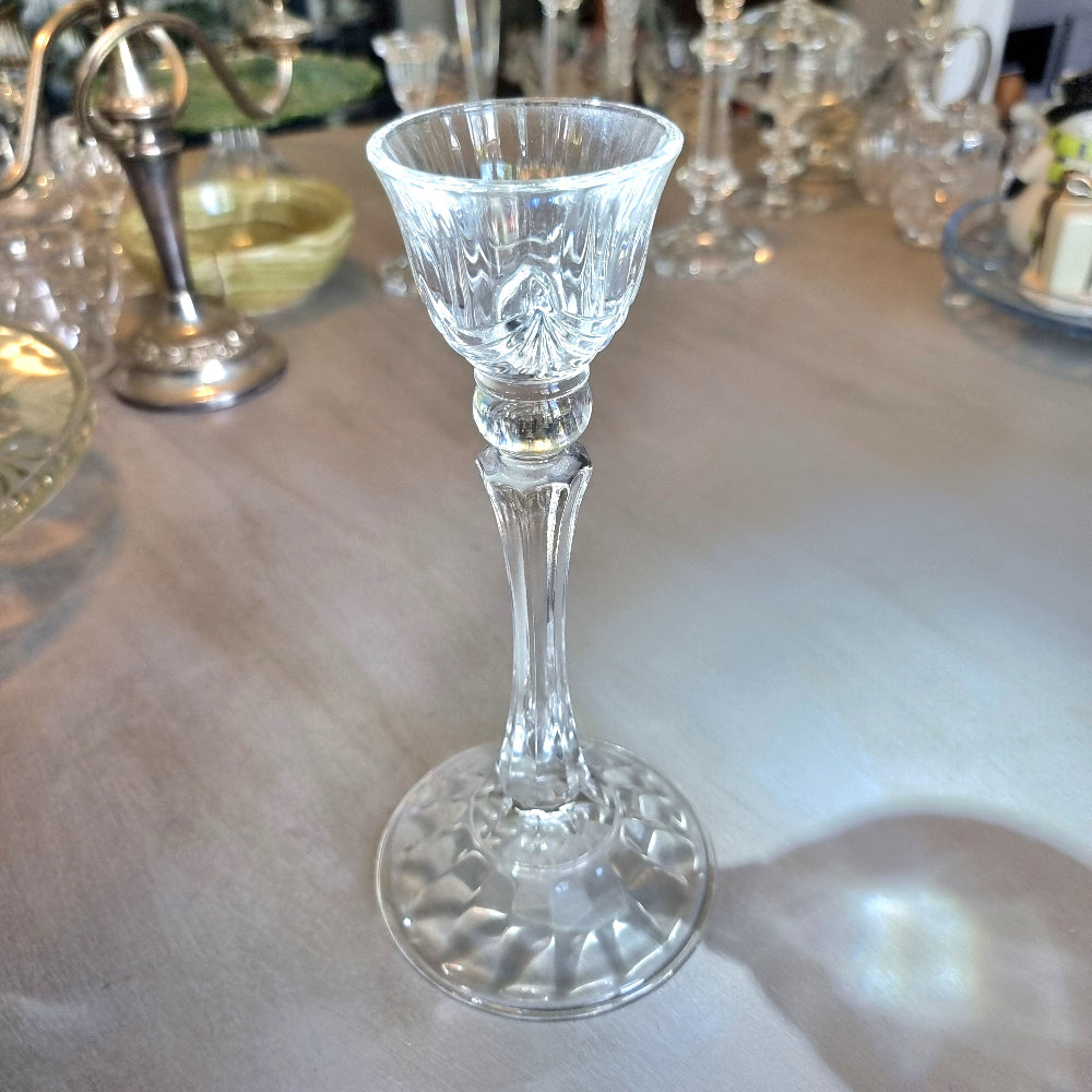 Tall crystal candle holder with fluted cup and textured base.