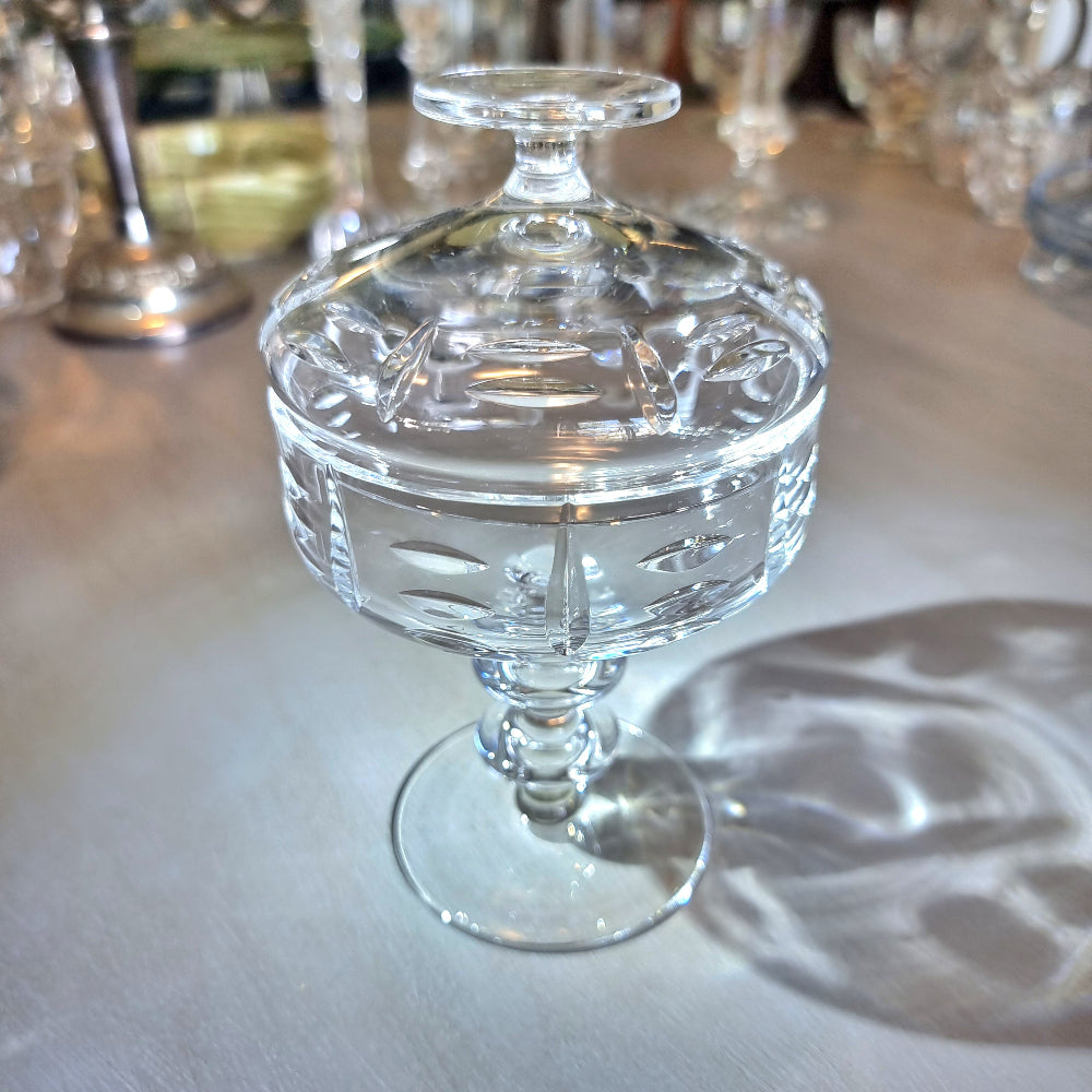 Cut crystal lidded compote with oval cut-outs and pedestal base.