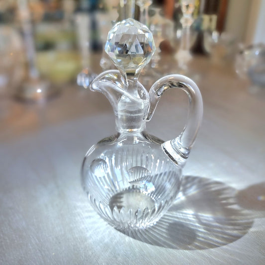Cut crystal cruet with faceted stopper and ribbed round body.