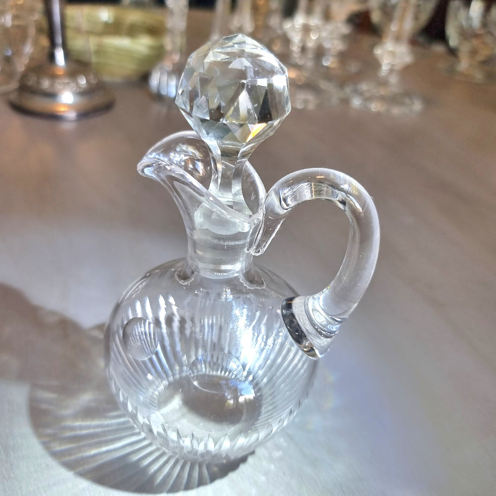 Cut crystal cruet with faceted stopper and ribbed round body.
