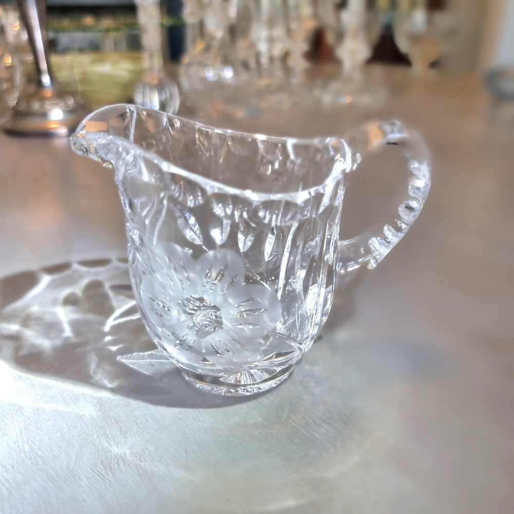 Etched crystal cream jug with frosted flower motif and cut-glass detailing.