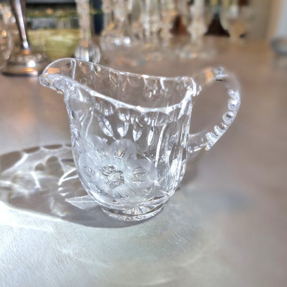 Etched crystal cream jug with frosted flower motif and cut-glass detailing.