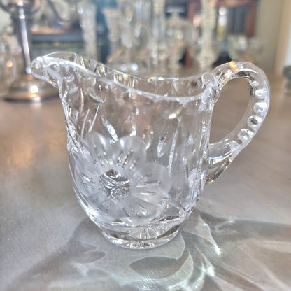 Etched crystal cream jug with frosted flower motif and cut-glass detailing.