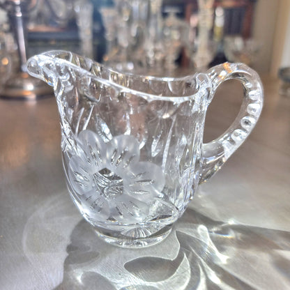 Etched crystal cream jug with frosted flower motif and cut-glass detailing.