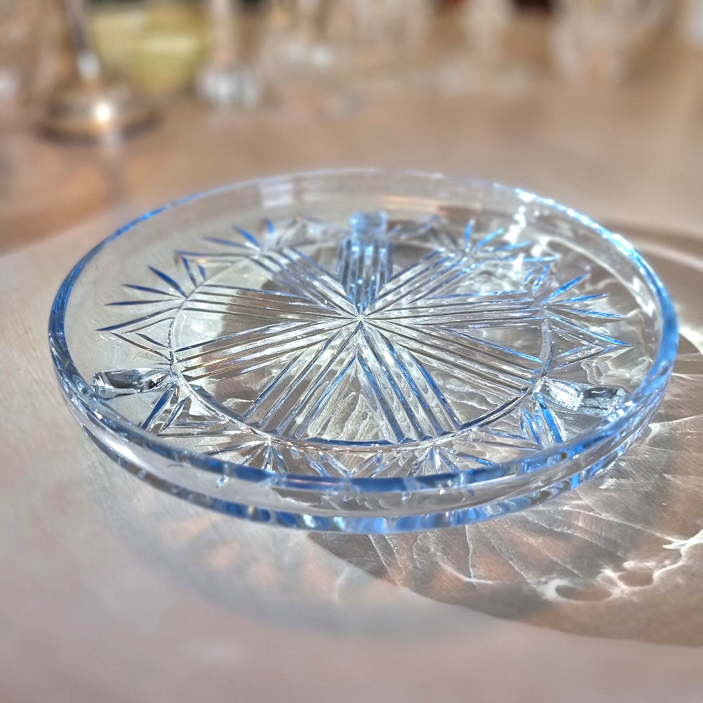 Art Deco pressed glass plate with geometric starburst pattern.