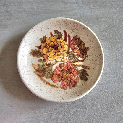 Vintage Palissy England dish with yellow and orange floral design and speckled glaze.