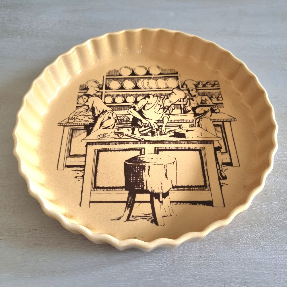 Vintage fluted plate with black pottery workshop illustration on warm yellow glaze.