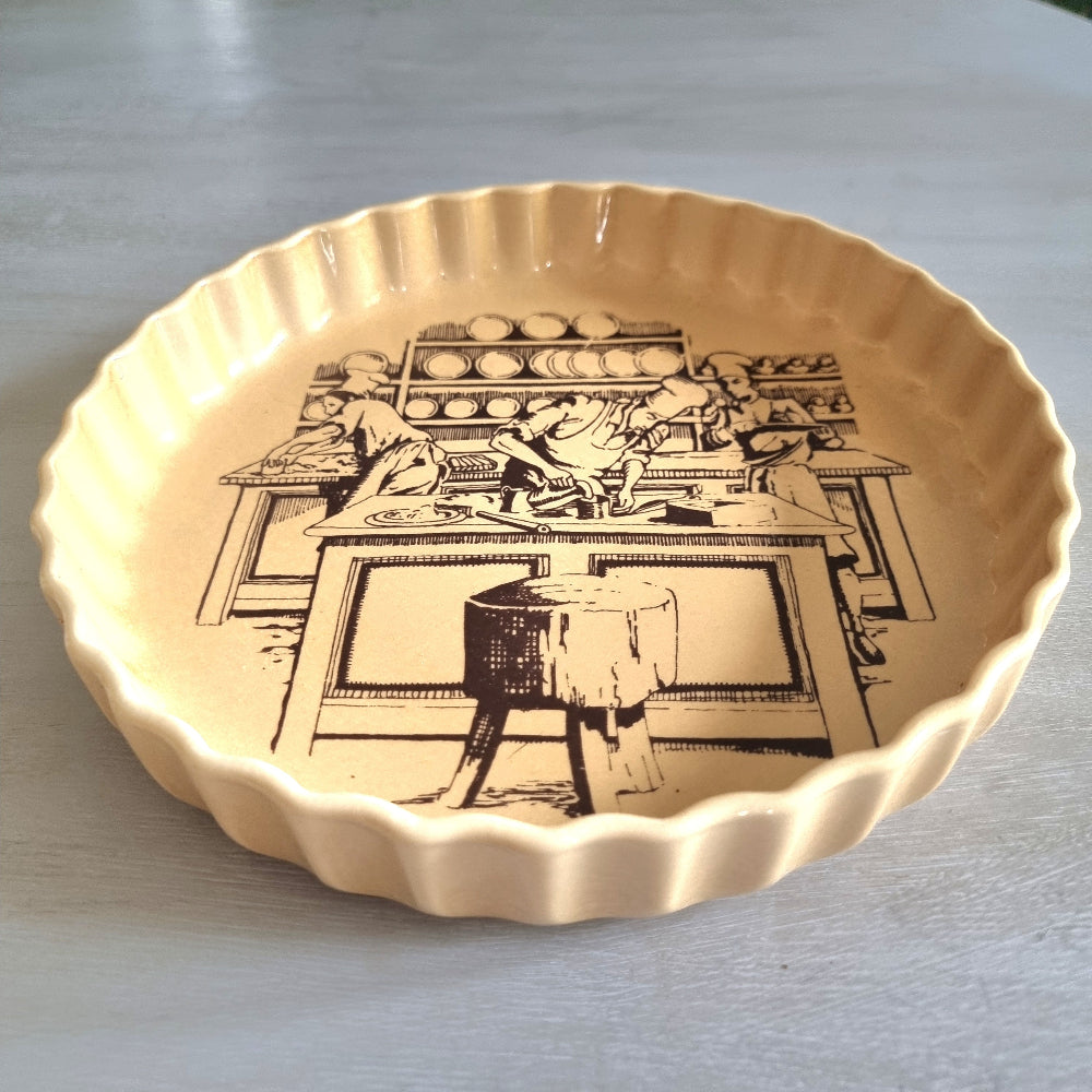 Vintage fluted plate with black pottery workshop illustration on warm yellow glaze.