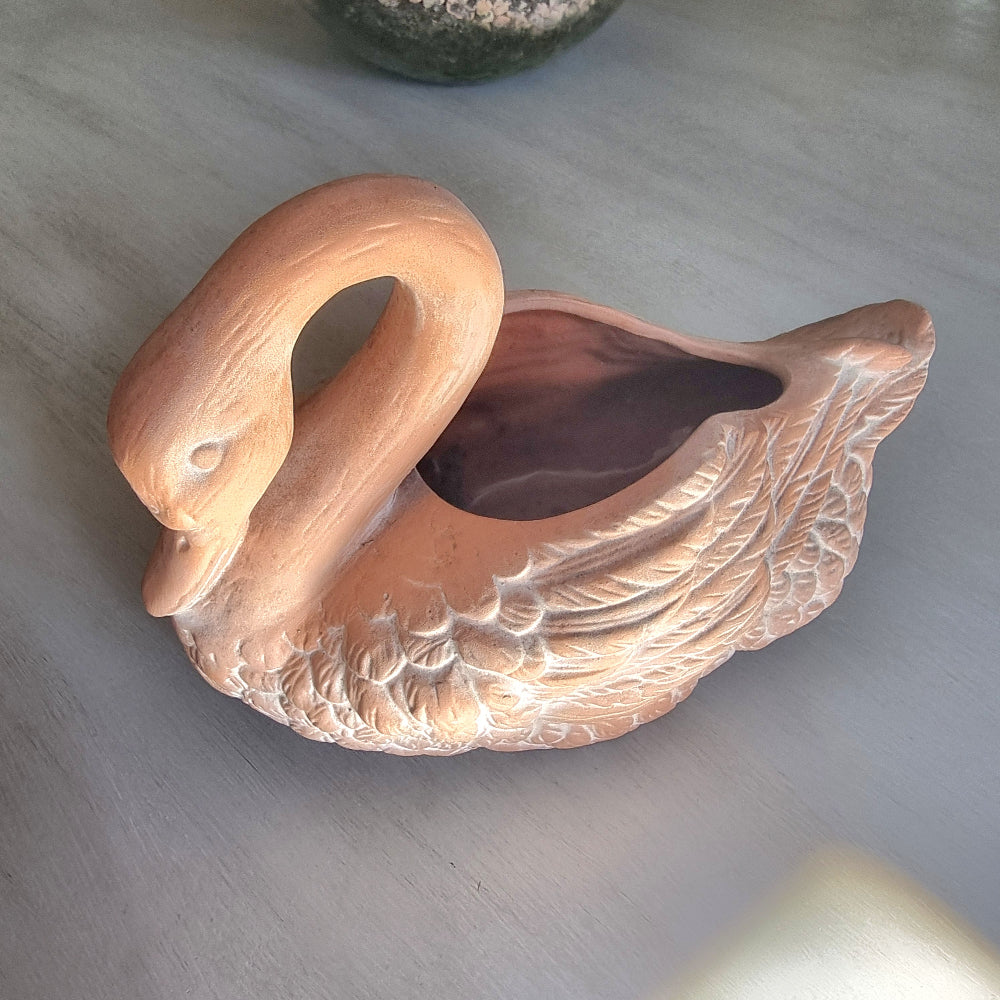Vintage ceramic swan planter with blush glaze and detailed feather texture, styled on a tabletop.