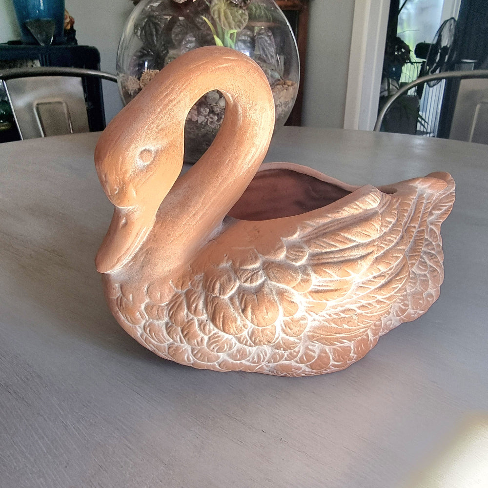 Vintage ceramic swan planter with blush glaze and detailed feather texture, styled on a tabletop.
