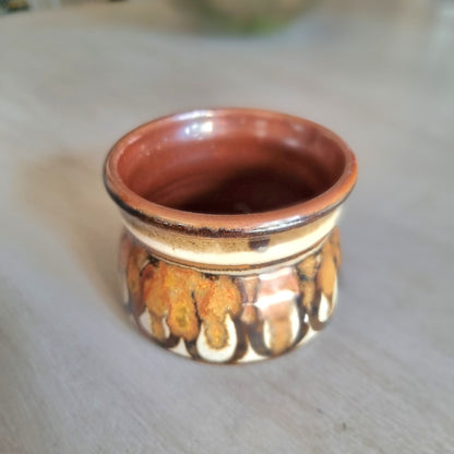 Vintage studio pottery planter with brown, caramel and cream glaze and textured drip pattern on a tabletop.