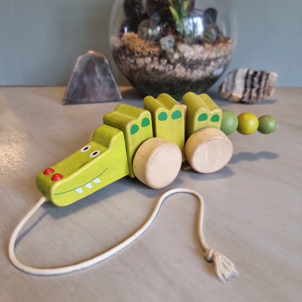 Vintage wooden pull-along crocodile toy in soft green with natural timber wheels