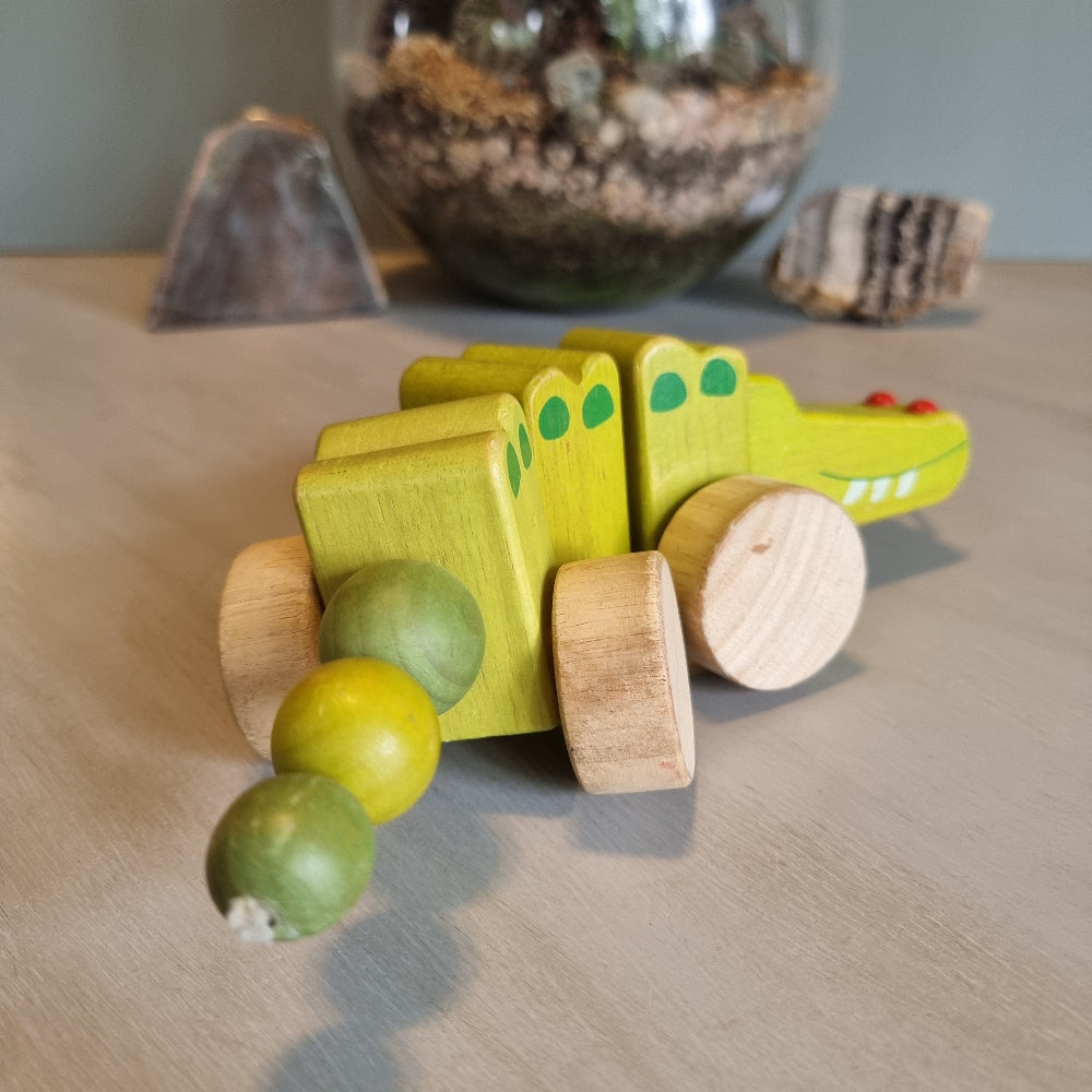 Vintage wooden pull-along crocodile toy in soft green with natural timber wheels