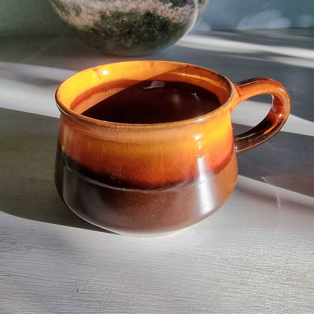 Vintage Crown Lynn amber and brown drip glaze ceramic soup/coffee cup with handle on a light surface.