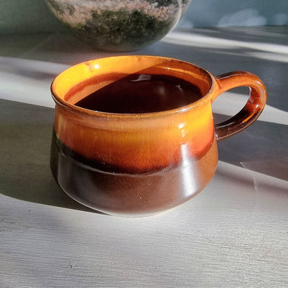 Vintage Crown Lynn amber and brown drip glaze ceramic soup/coffee cup with handle on a light surface.