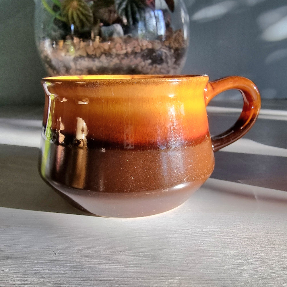 Vintage Crown Lynn amber and brown drip glaze ceramic soup/coffee cup with handle on a light surface.
