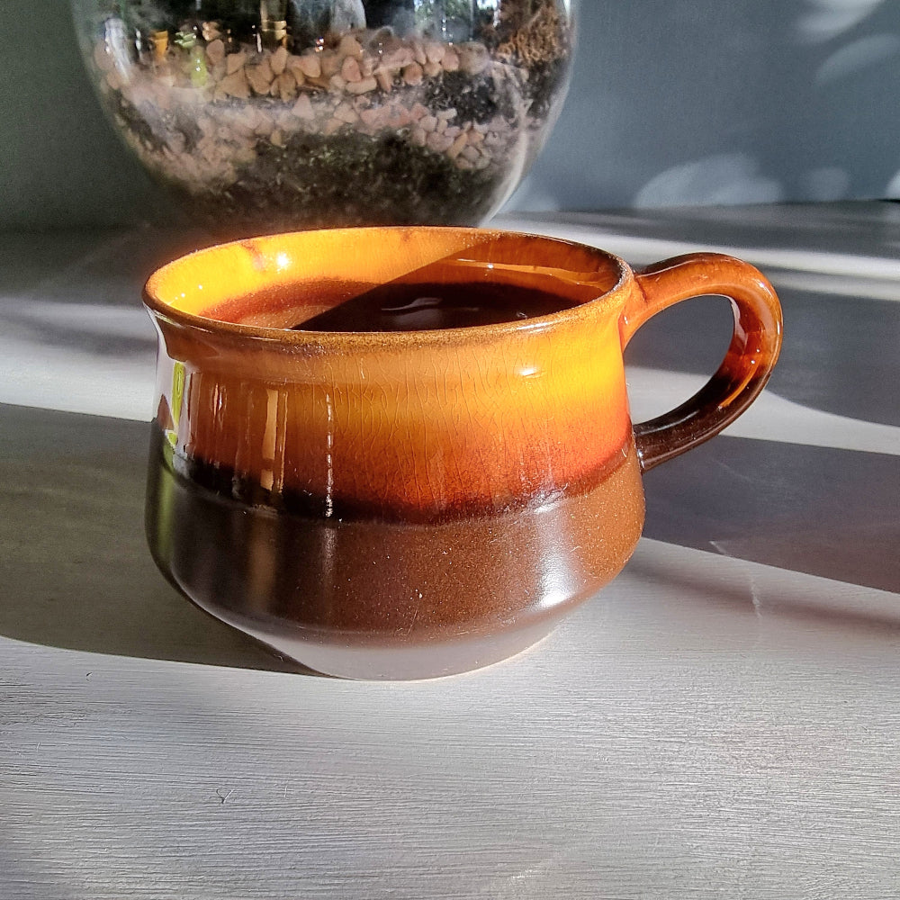 Vintage Crown Lynn amber and brown drip glaze ceramic soup/coffee cup with handle on a light surface.