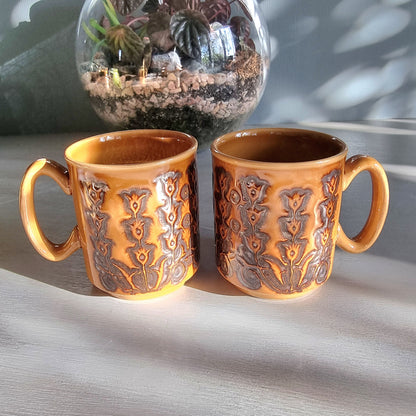 Pair of vintage Winchcombe Pottery floral mugs in honey-brown glaze with embossed design, made in England.