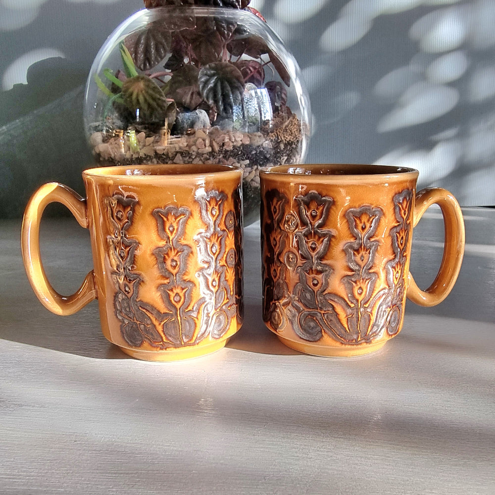 Pair of vintage Winchcombe Pottery floral mugs in honey-brown glaze with embossed design, made in England.