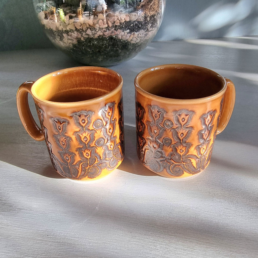 Pair of vintage Winchcombe Pottery floral mugs in honey-brown glaze with embossed design, made in England.