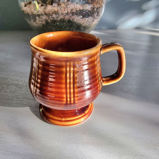 Vintage brown pedestal mug with ribbed sides and raised base, retro stoneware coffee mug.