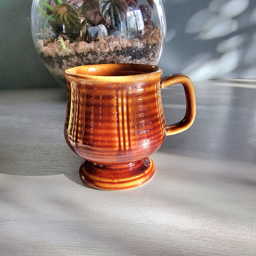 Vintage brown pedestal mug with ribbed sides and raised base, retro stoneware coffee mug.