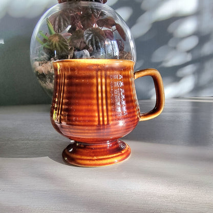 Vintage brown pedestal mug with ribbed sides and raised base, retro stoneware coffee mug.