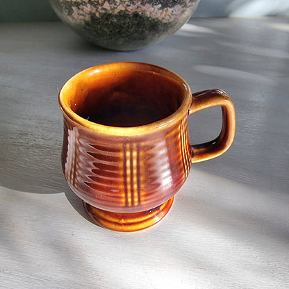 Vintage brown pedestal mug with ribbed sides and raised base, retro stoneware coffee mug.