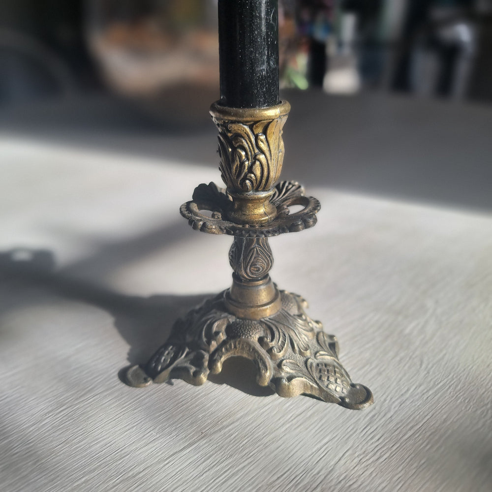Ornate brass candlestick with detailed tri-foot base stamped Made in Italy.