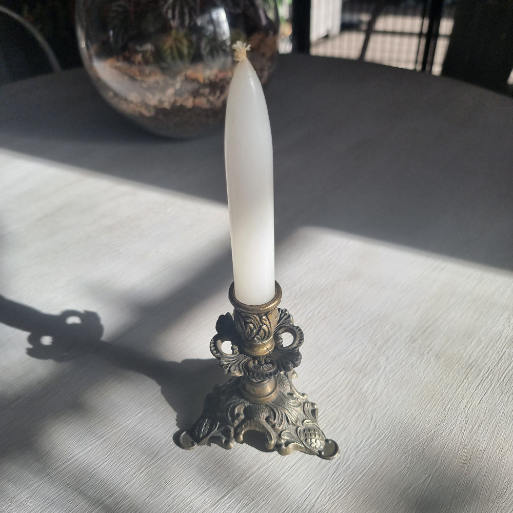 Ornate brass candlestick with detailed tri-foot base stamped Made in Italy.
