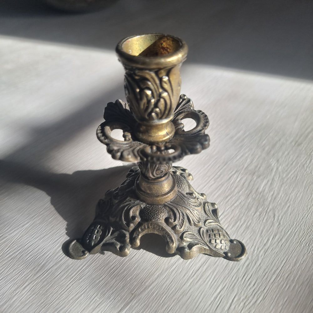 Ornate brass candlestick with detailed tri-foot base stamped Made in Italy.