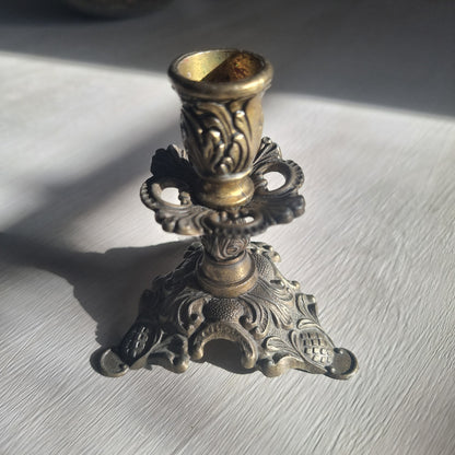 Ornate brass candlestick with detailed tri-foot base stamped Made in Italy.