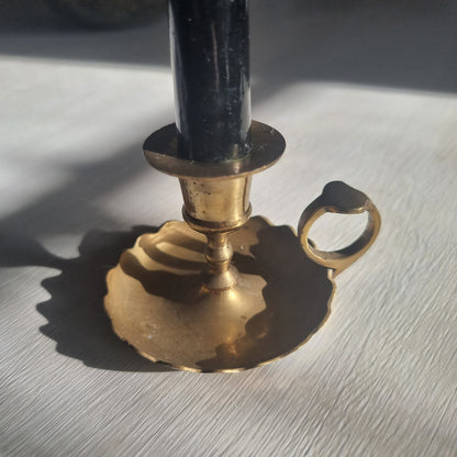 Vintage brass chamberstick with scalloped drip tray and finger handle.