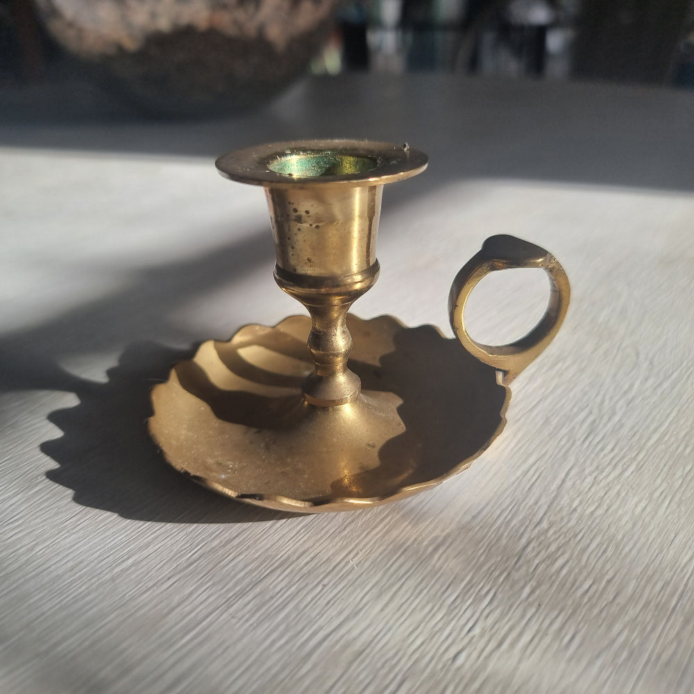 Vintage brass chamberstick with scalloped drip tray and finger handle.